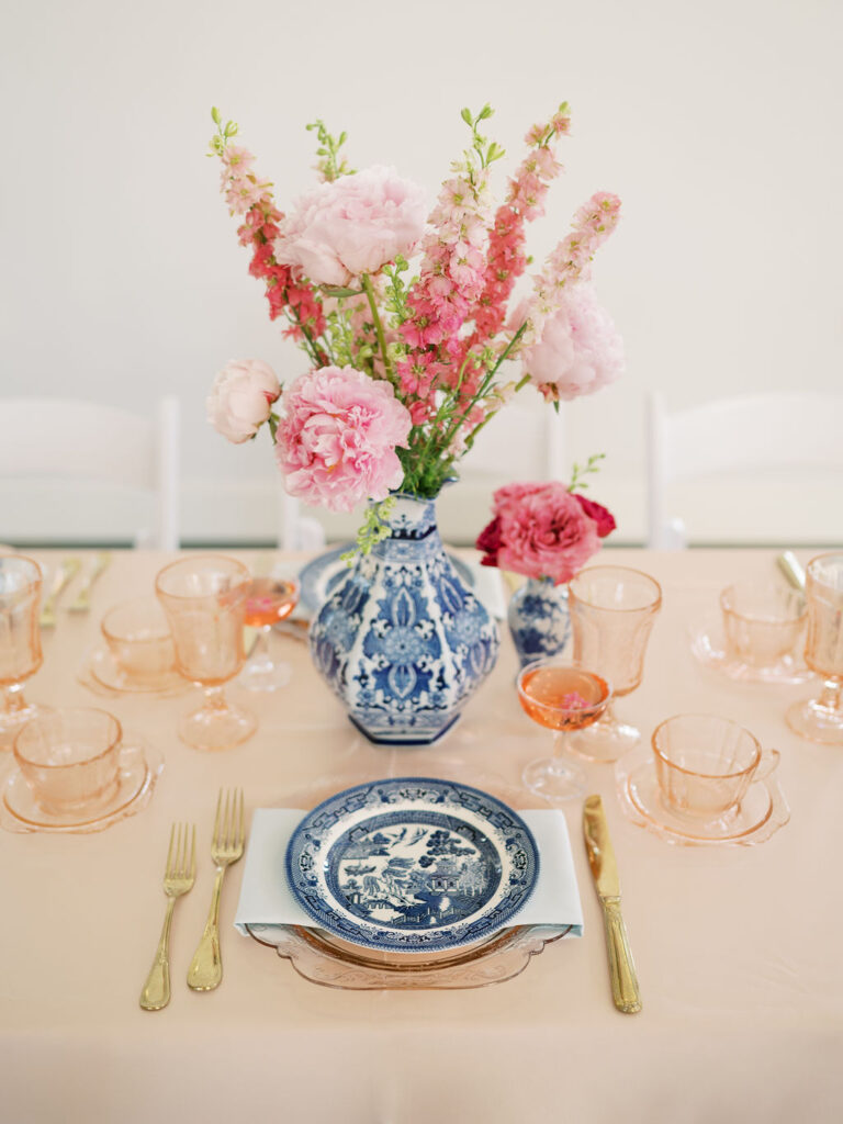 Wedding tablescape with blue and white chinoiserie china and bright pink flowers.