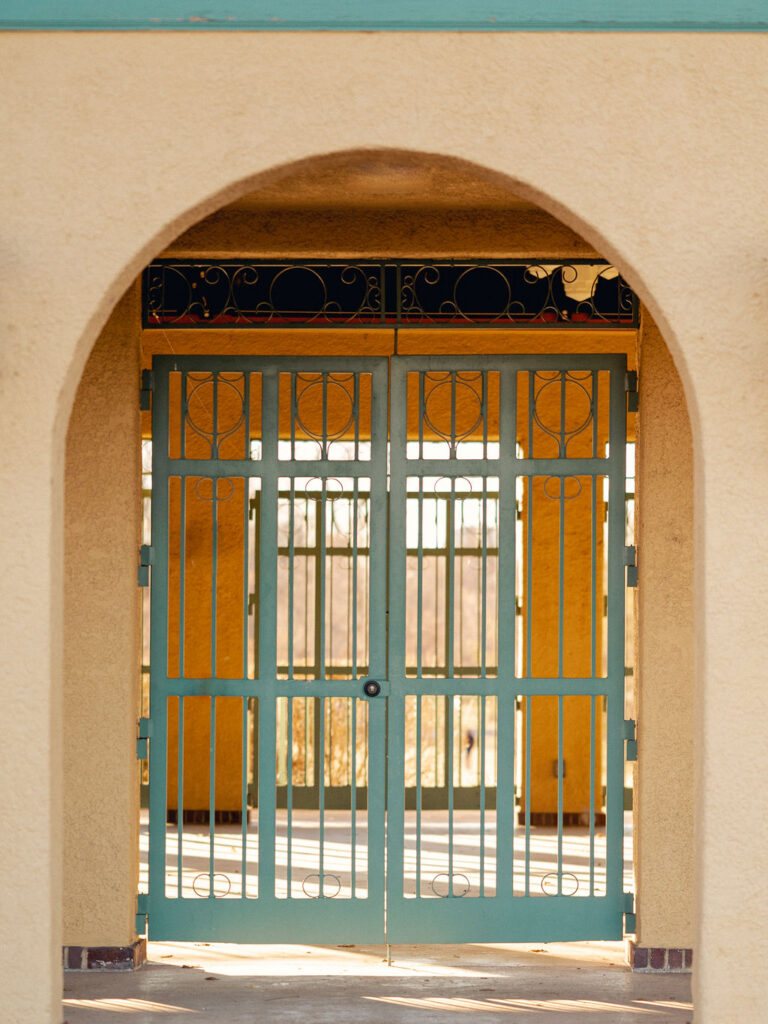 A gated archway with a teal gate at City Park in Denver, Colorado.