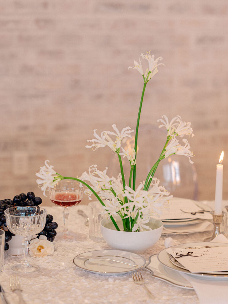 A wedding tablescape featuring a modern arrangement of white florals.
