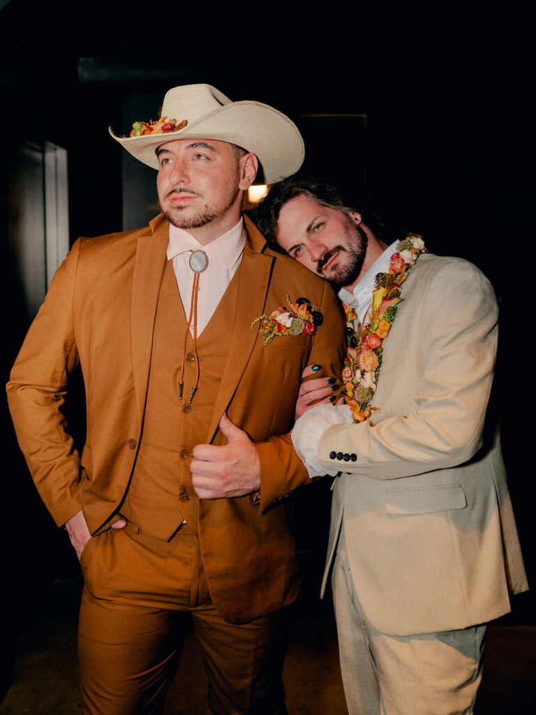 Two grooms stand together in a basement speakeasy in Boulder, Colorado.