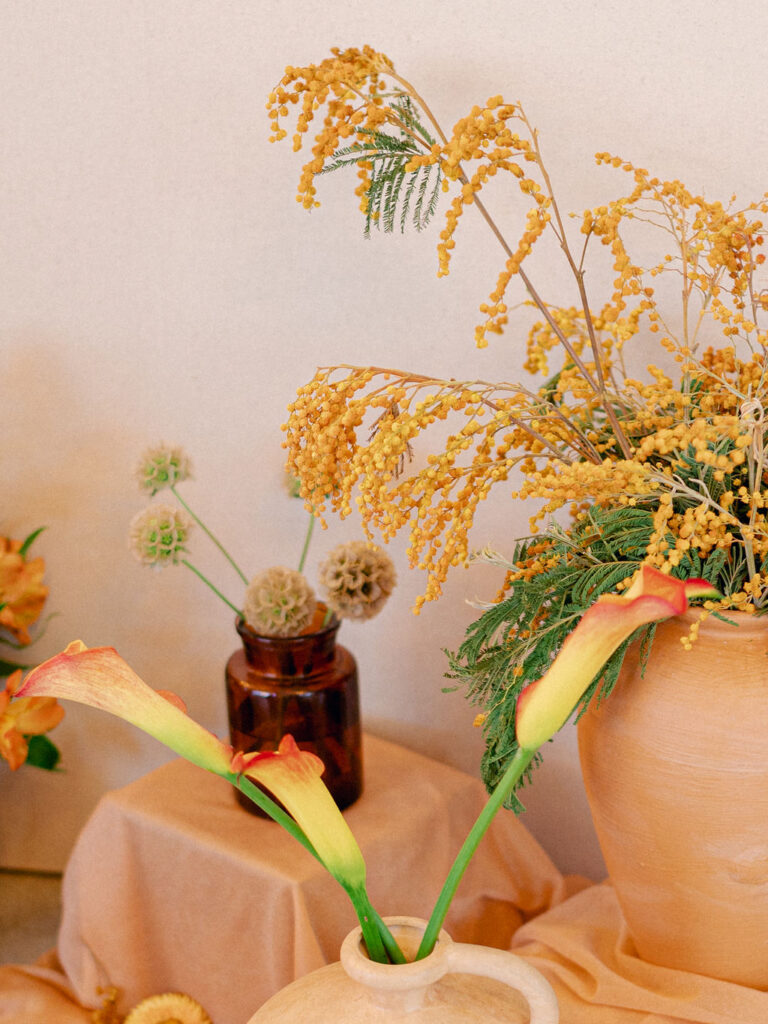 Orange florals in terracotta vases at a western inspired wedding in Colorado.
