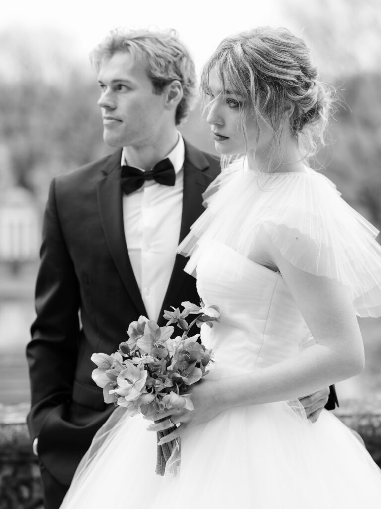 Black and white portrait of bride and groom looking into distance.