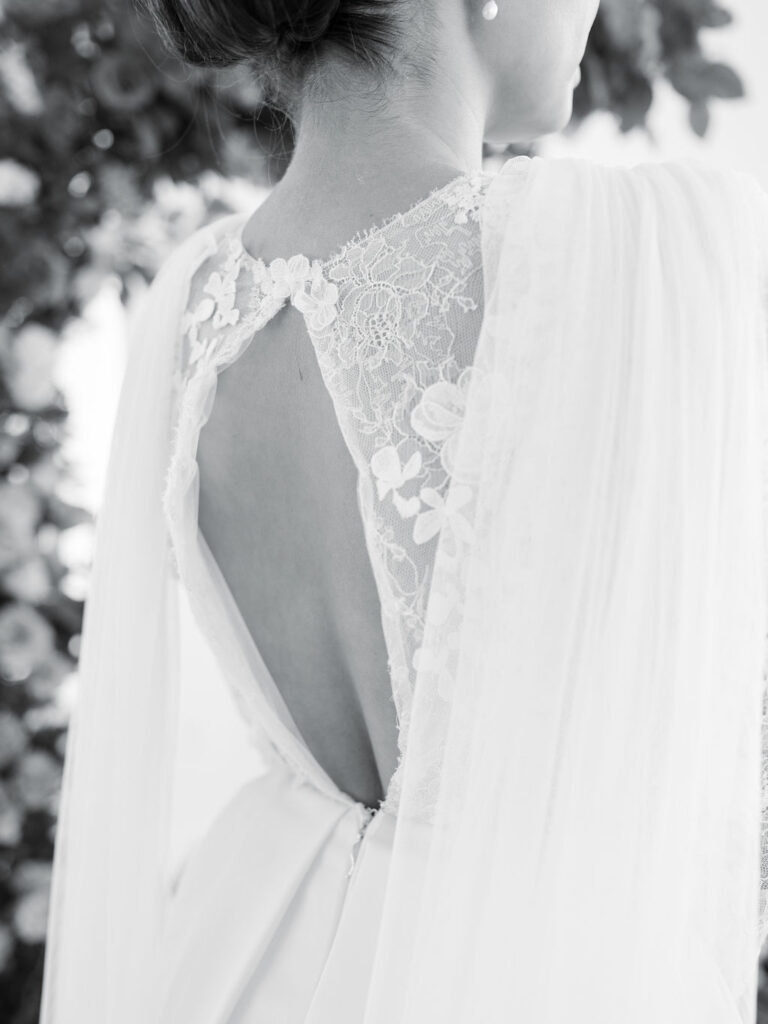 A close up black and white image of a cut out in the back of a wedding gown.