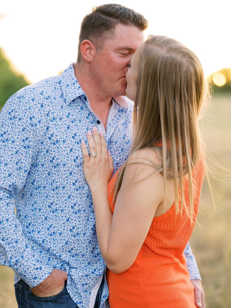 Bride and groom kiss during engagement session on family ranch