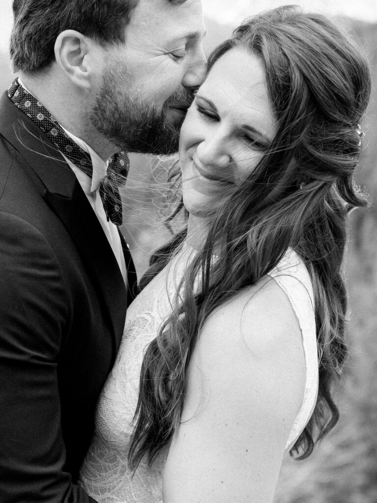 A bride and groom hold each other close in a sweet black and white wedding portrait in Vail, Colorado.