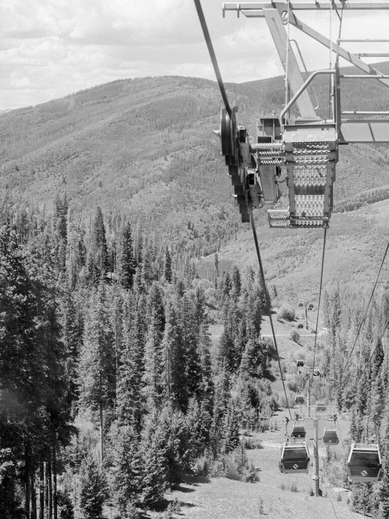 A black and white photograph of the gondola at Vail Mountain on a summer day.