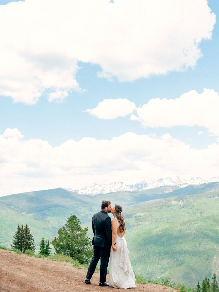 A bride and groom share a kiss among the vibrant mountains of Vail, Colorado.