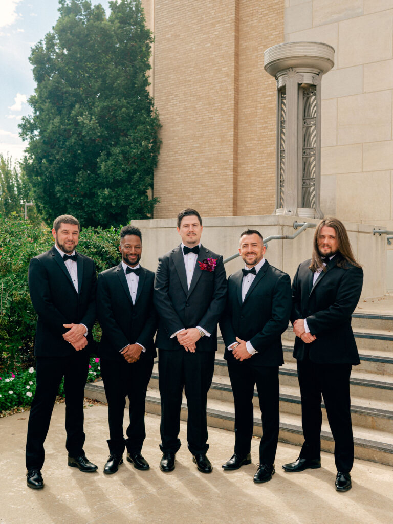 A classic groomsmen portrait in front of historic OKC wedding venue, the OKC Civic Center.