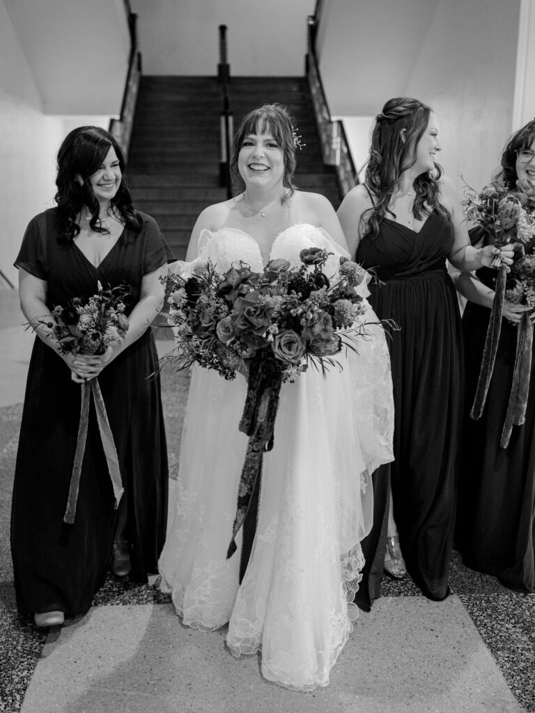 A bride and her bridesmaids walk in the lobby of the historic Oklahoma City wedding venue, OKC Civic Center.