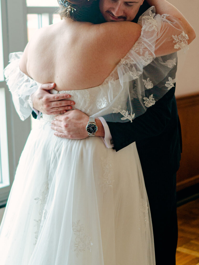 A bride and groom hug during the emotional first look at their Oklahoma City wedding.