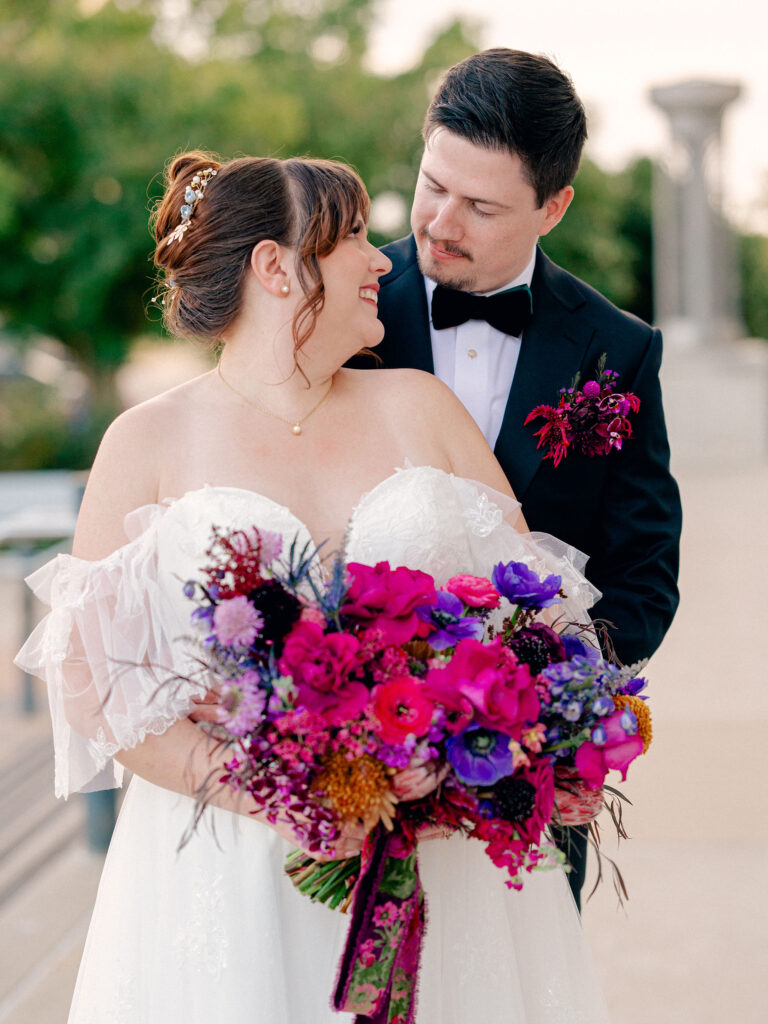 A bride and groom look at each other in a classic and colorful portrait at their Oklahoma City wedding.