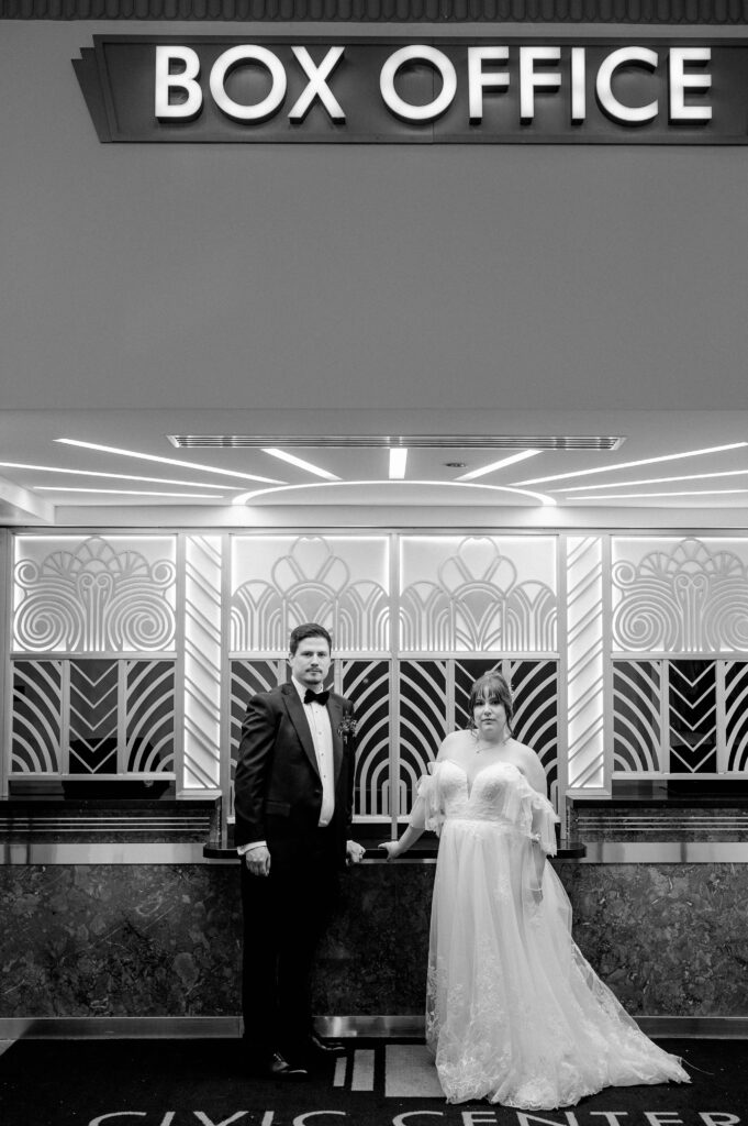 A bride and groom take an editorial wedding portrait in the art deco Box Office of their Oklahoma City wedding venue.