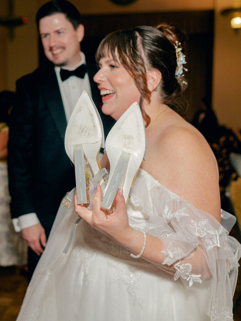 A bride and groom dance with their guests at their wedding reception.